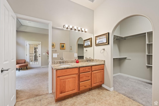 full bath featuring tile patterned flooring, double vanity, and baseboards