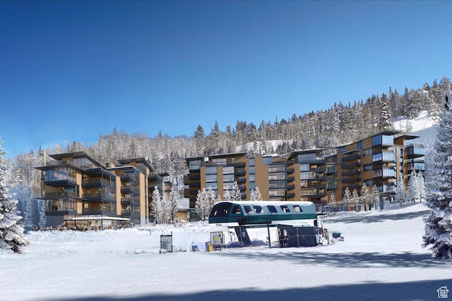 snow covered building with a view of apartment building / complex