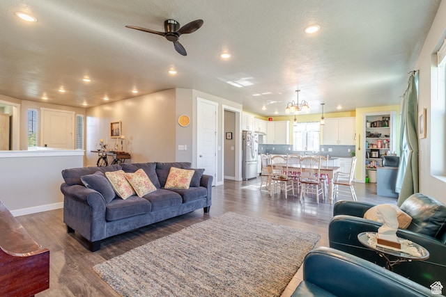 1517 E Kelsey Dr, Eagle Mountain, UT 84005 - living room with recessed lighting, ceiling fan, dark wood-style flooring, baseboards, and a chandelier