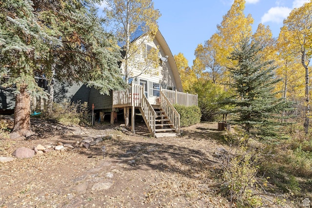 back of house featuring stairway and a deck