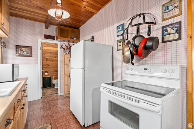 kitchen with white appliances, wallpapered walls, wood ceiling, and light countertops