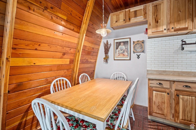 dining area with brick patterned flooring, wooden ceiling, wooden walls, and wallpapered walls
