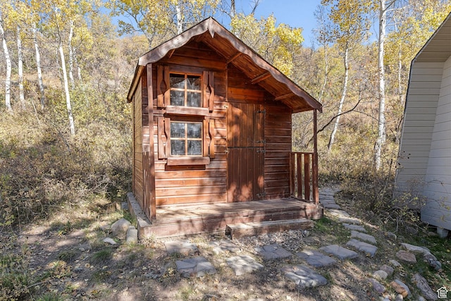 view of outdoor structure featuring an outbuilding and a wooded view