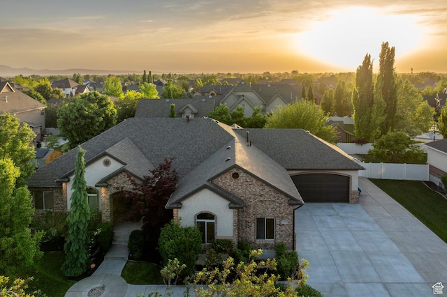 view of front of property featuring fence, driveway, a residential view, and roof with shingles