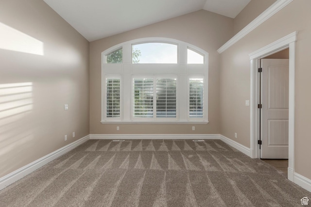 empty room featuring vaulted ceiling, carpet flooring, and baseboards