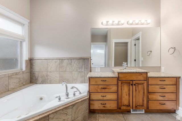 bathroom featuring a tub with jets, vanity, and tile patterned floors