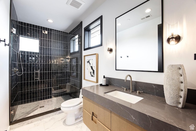 full bathroom featuring marble finish floors, a tile shower, toilet, recessed lighting, and vanity