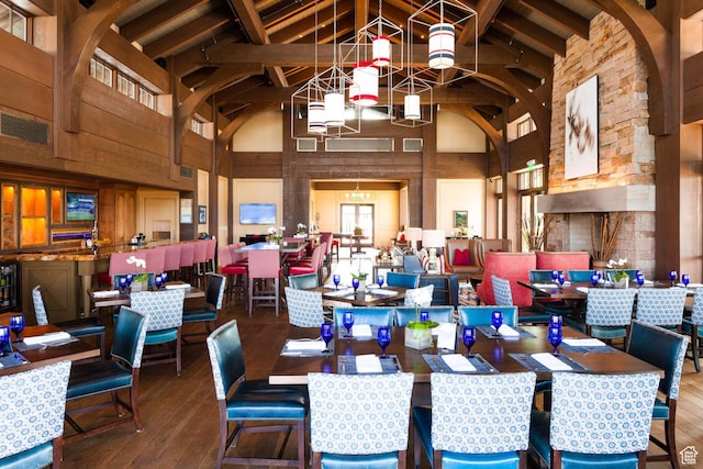 dining area featuring high vaulted ceiling, hardwood / wood-style floors, and beam ceiling