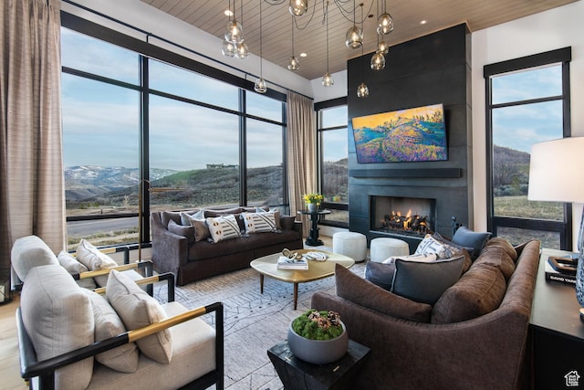 living area featuring a warm lit fireplace and wood ceiling