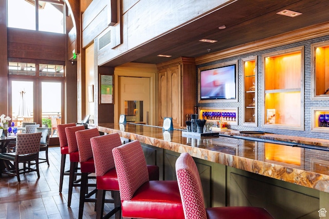 bar with plenty of natural light, wood-type flooring, and tasteful backsplash
