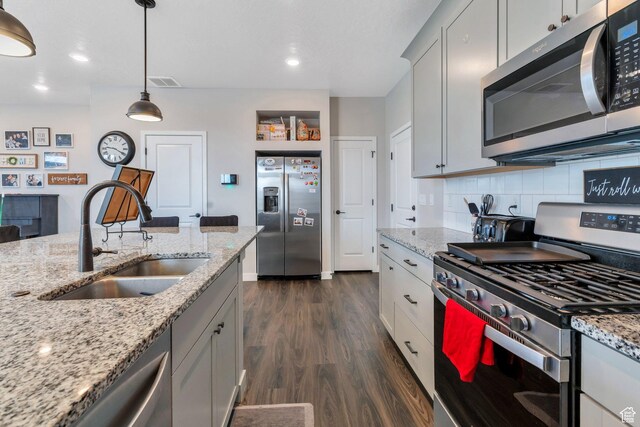 24 S Baker Spring Cv, Saratoga Springs, UT 84045 - kitchen with stainless steel appliances, a sink, dark wood finished floors, decorative backsplash, and pendant lighting