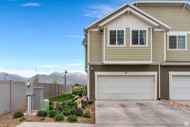 24 S Baker Spring Cv, Saratoga Springs, UT 84045 - view of property exterior featuring a mountain view, fence, concrete driveway, a garage, and board and batten siding