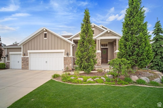 craftsman-style home featuring stone siding, board and batten siding, a garage, driveway, and a front yard