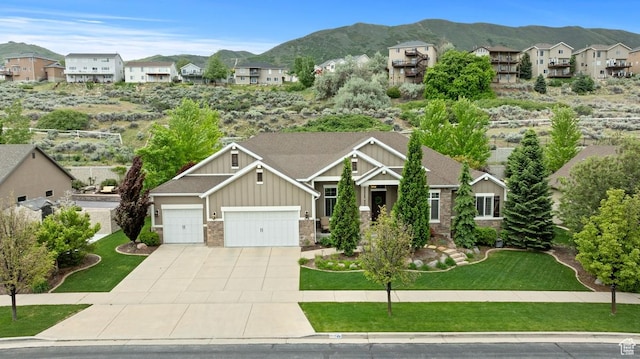 craftsman-style house with board and batten siding, a mountain view, a residential view, and concrete driveway