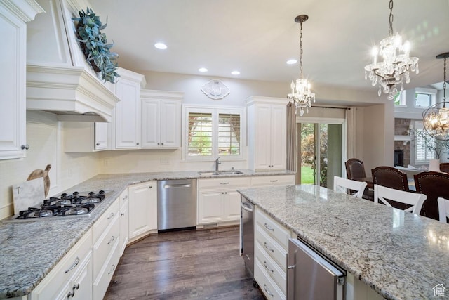 kitchen featuring a chandelier, stainless steel appliances, a sink, white cabinetry, and recessed lighting