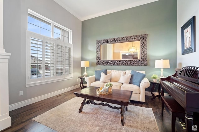 living area with wood finished floors, healthy amount of natural light, baseboards, and ornamental molding