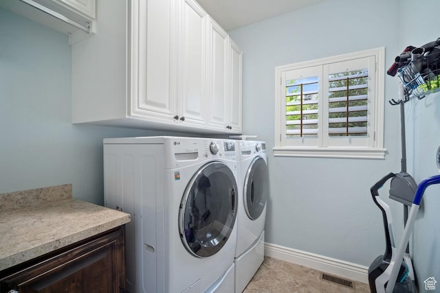 laundry room featuring cabinet space, washer and clothes dryer, and baseboards