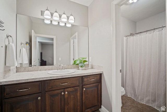 bathroom with toilet, vanity, and curtained shower