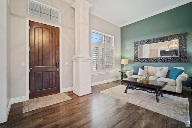 entrance foyer with ornate columns, wood finished floors, baseboards, crown molding, and a chandelier