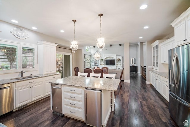 kitchen with stainless steel appliances, a sink, a chandelier, a kitchen island, and recessed lighting