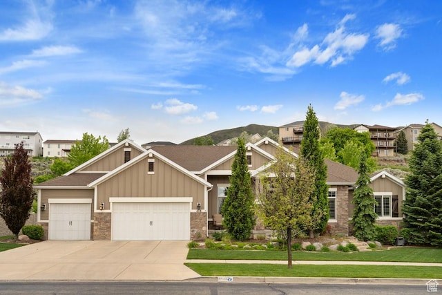 view of front of property with board and batten siding, stone siding, concrete driveway, a garage, and a front lawn