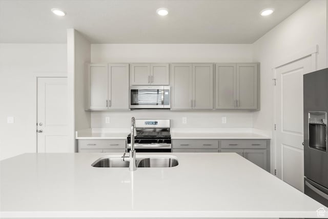 3457 S 3100 W Unit 174, West Haven, UT 84401 - kitchen featuring appliances with stainless steel finishes, gray cabinets, light countertops, recessed lighting, and a center island with sink