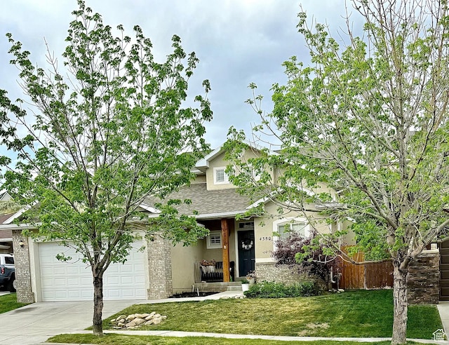4382 N Pheasant Ridge Trl, Lehi, UT 84043 - view of front of home featuring concrete driveway, a front lawn, a shingled roof, stucco siding, and a garage