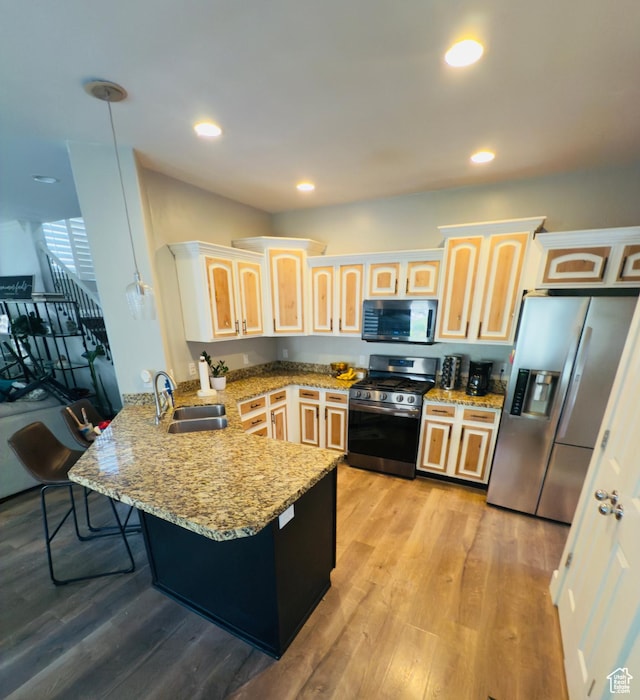 4382 N Pheasant Ridge Trl, Lehi, UT 84043 - kitchen featuring appliances with stainless steel finishes, a peninsula, a sink, light stone countertops, and a kitchen breakfast bar