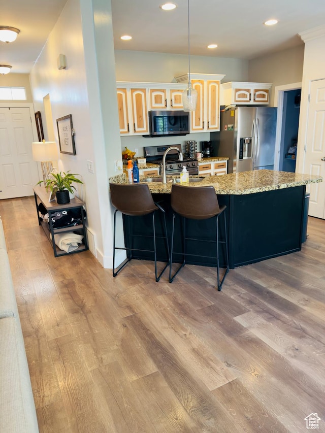 4382 N Pheasant Ridge Trl, Lehi, UT 84043 - kitchen with appliances with stainless steel finishes, a peninsula, light wood-style floors, a breakfast bar, and glass insert cabinets