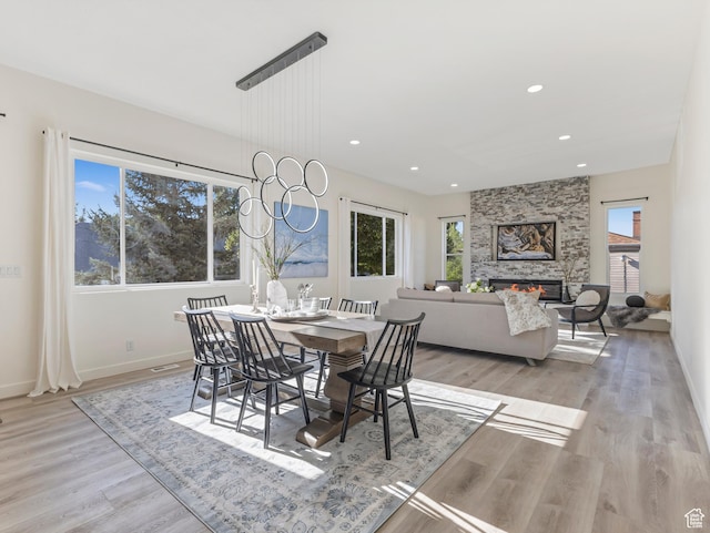 dining area with plenty of natural light, light wood finished floors, recessed lighting, and baseboards