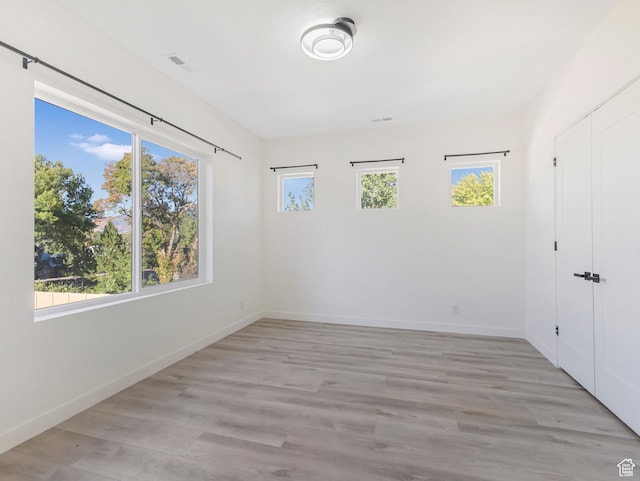 spare room featuring baseboards and wood finished floors