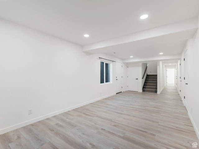 spare room featuring stairs, recessed lighting, baseboards, and light wood-type flooring