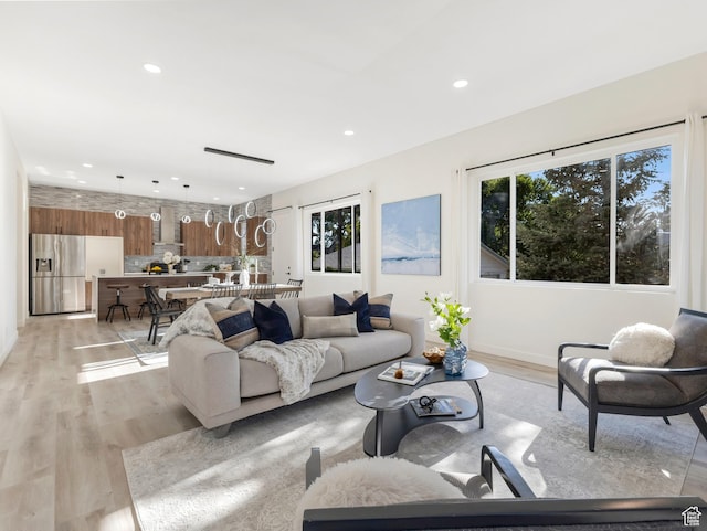 living area featuring plenty of natural light, light wood finished floors, and recessed lighting
