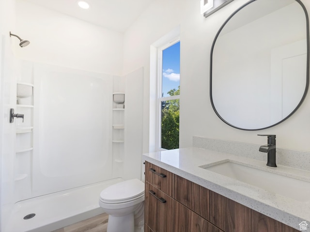 bathroom with vanity, a stall shower, toilet, recessed lighting, and wood finished floors