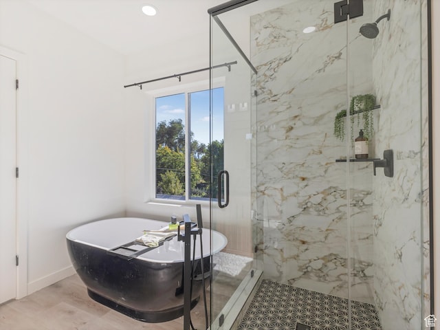 full bath featuring a freestanding bath, a marble finish shower, and recessed lighting