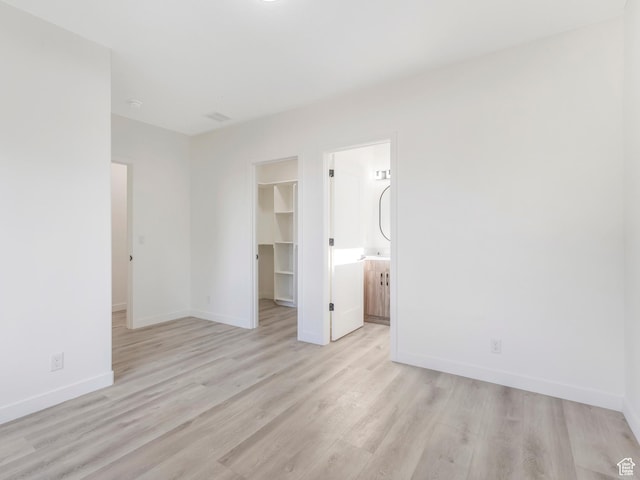 empty room featuring light wood finished floors and baseboards