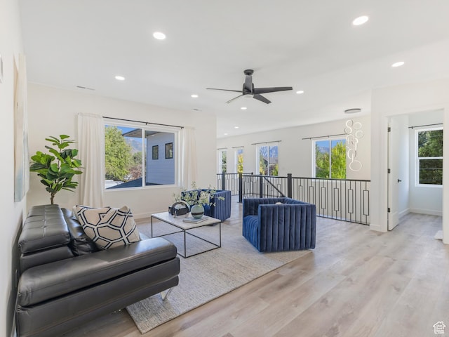 living area featuring recessed lighting, light wood-type flooring, a ceiling fan, and baseboards