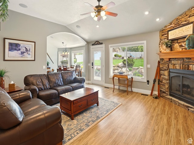 7639 S 475 W, Willard, UT 84340 - living area featuring vaulted ceiling, arched walkways, a stone fireplace, ceiling fan, and light wood-style flooring