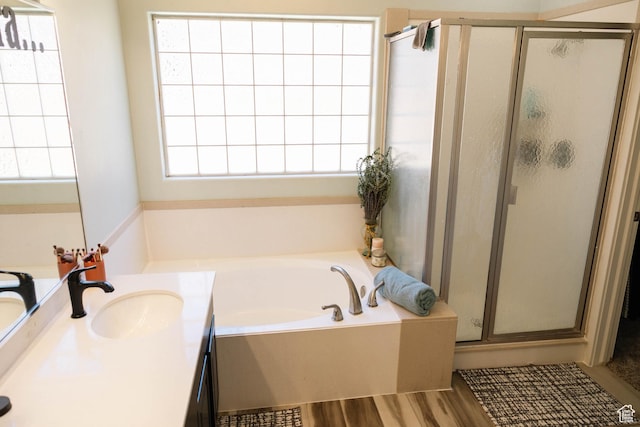 bathroom with a bath, a shower stall, vanity, and wood finished floors