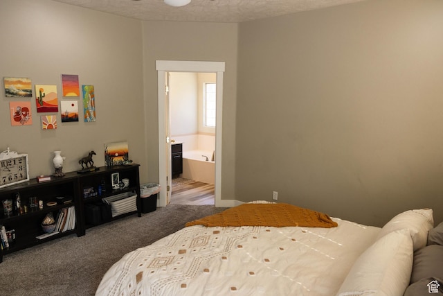 carpeted bedroom with connected bathroom and a textured ceiling
