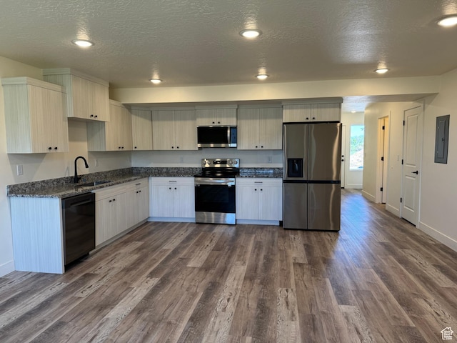 kitchen with appliances with stainless steel finishes, a sink, dark wood-style floors, electric panel, and a textured ceiling