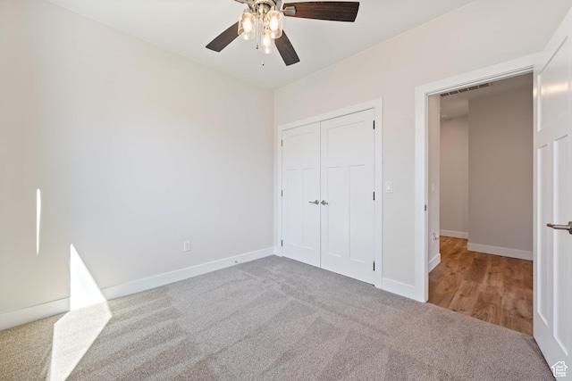 unfurnished bedroom with carpet, baseboards, a closet, and ceiling fan