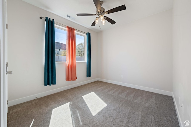 carpeted spare room with baseboards and ceiling fan