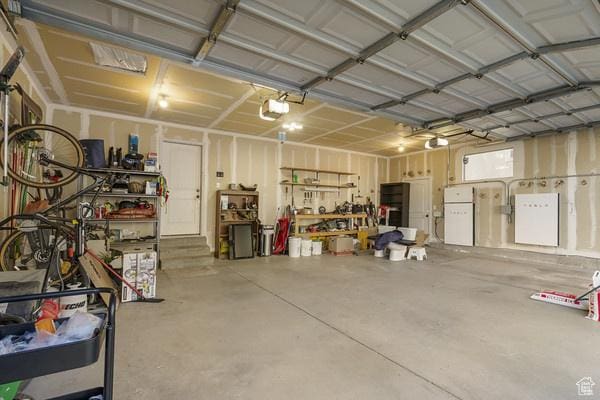 6966 N S Pass Rd, Eagle Mountain, UT 84005 - garage with a garage door opener and a workshop area
