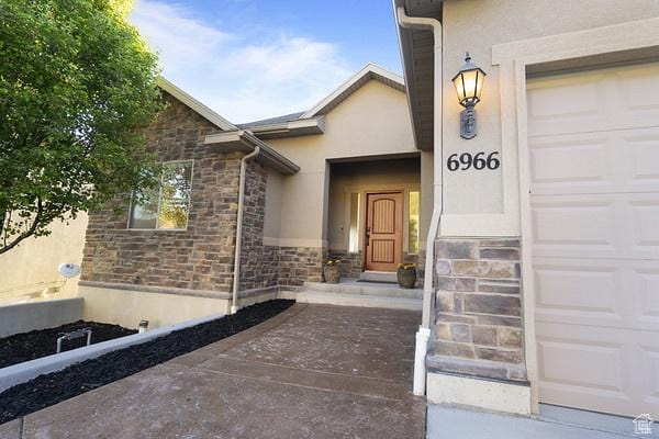 6966 N S Pass Rd, Eagle Mountain, UT 84005 - entrance to property featuring stucco siding, stone siding, and a garage