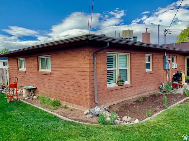 111 W 570 N, Richfield, UT 84701 - view of property exterior with a lawn, a chimney, central AC unit, and brick siding
