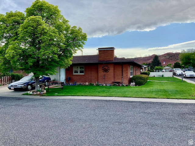 111 W 570 N, Richfield, UT 84701 - view of front of house with a chimney, brick siding, a front lawn, and a mountain view