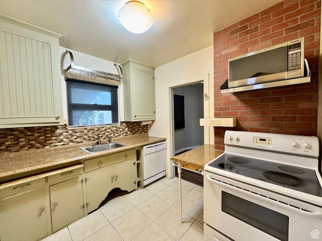 kitchen featuring white appliances, a sink, light tile patterned floors, backsplash, and light countertops