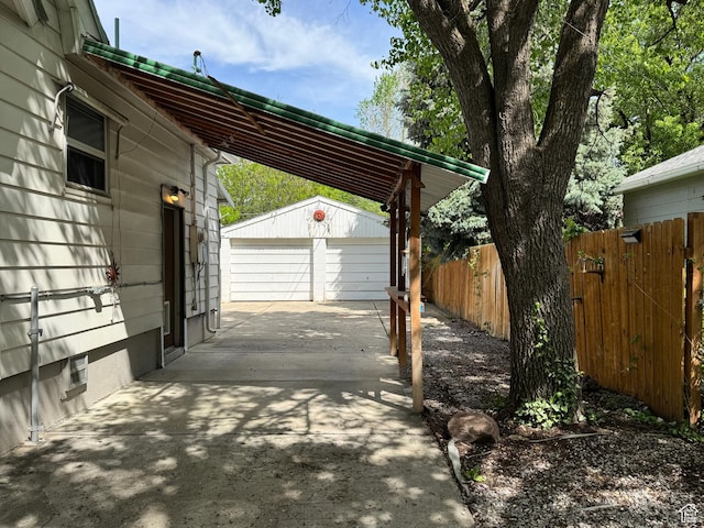 view of car parking with fence and a detached garage