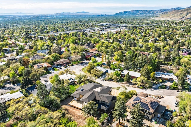 aerial view of property and surrounding area featuring mountains and nearby suburban area